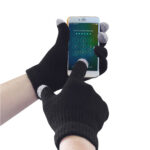 Čierne pletené rukavice Portwest GL16 pri ovládaní dotykového displeja mobilu